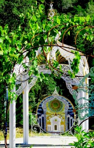 Metal Hymn with mosaic seen through Blanket of Flowers arbor